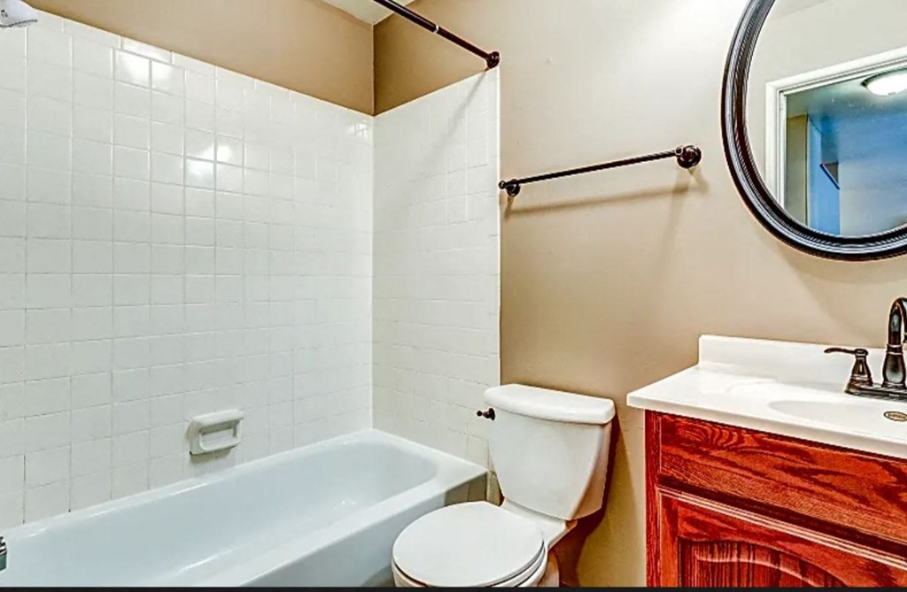a bathroom with a toilet and a tub and a sink
