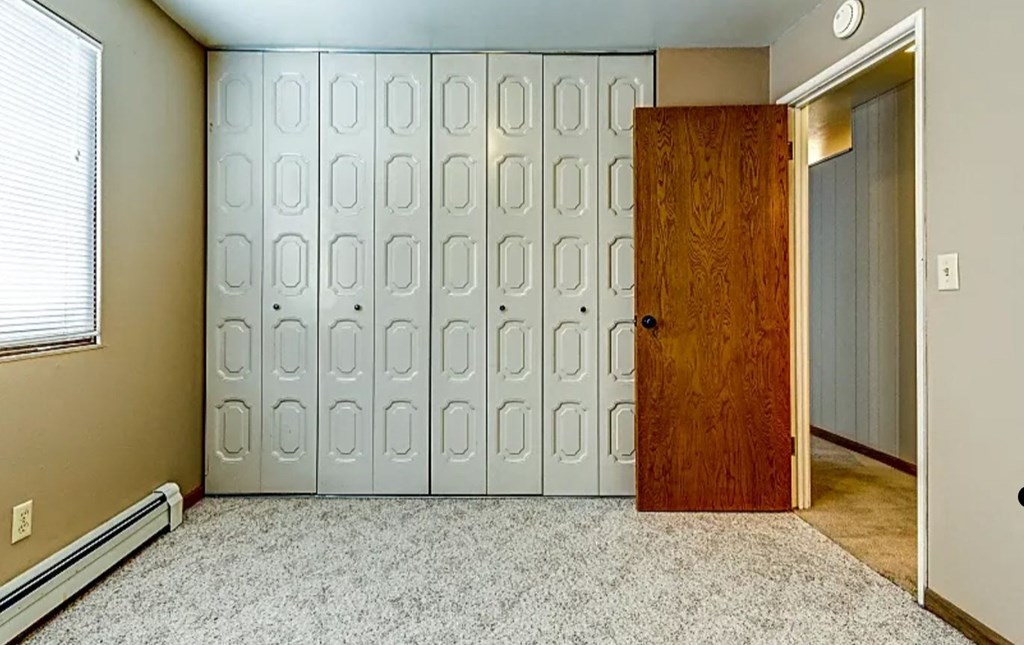 an empty room with a closet and a door