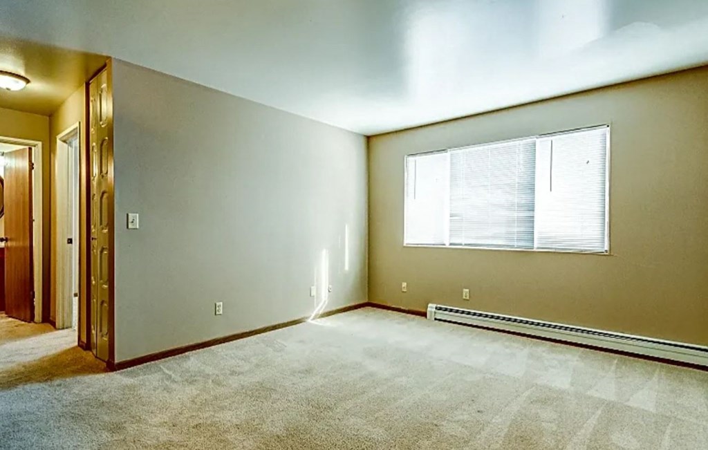 an empty room with a window and a door