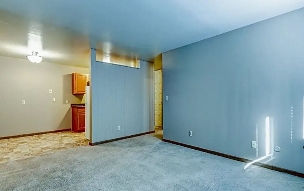an empty room with a blue wall and a bathroom