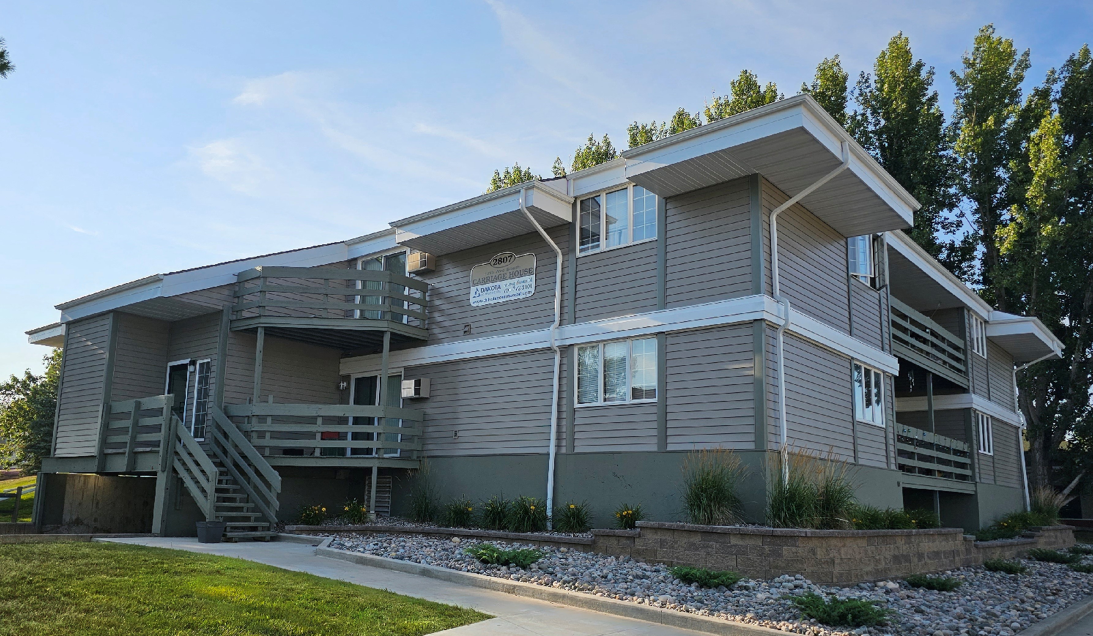 a gray house with a sidewalk in front of it