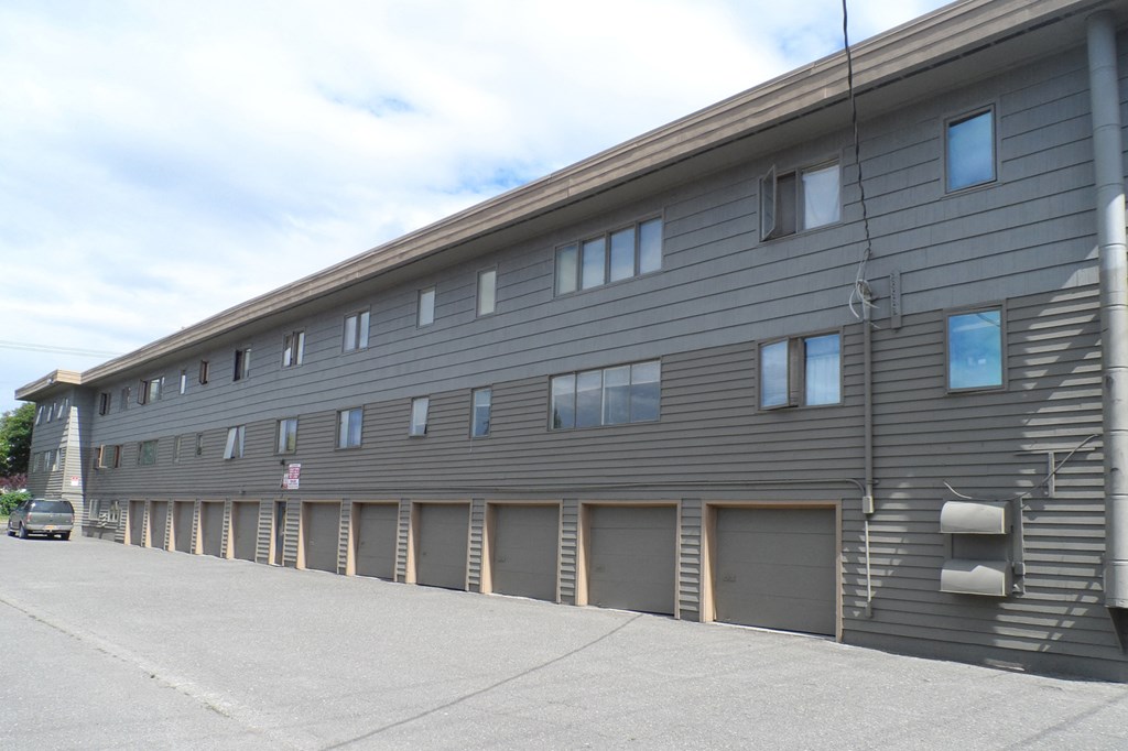 the side of a building with a row of garage doors