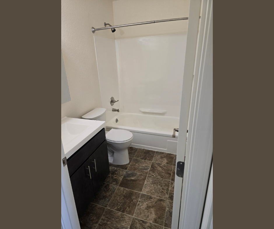 A bathroom with a toilet, sink, and bathtub.