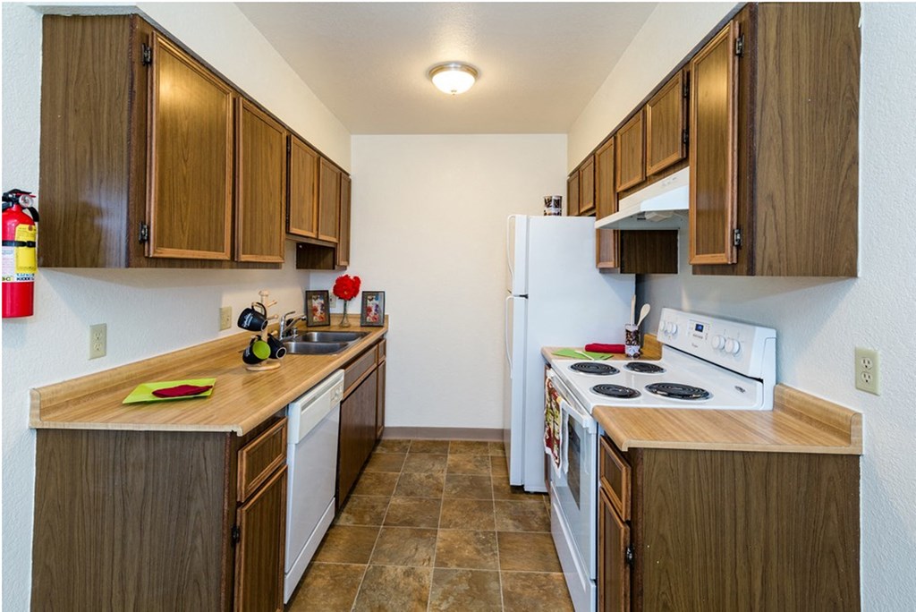 a kitchen with white appliances and wooden cabinets