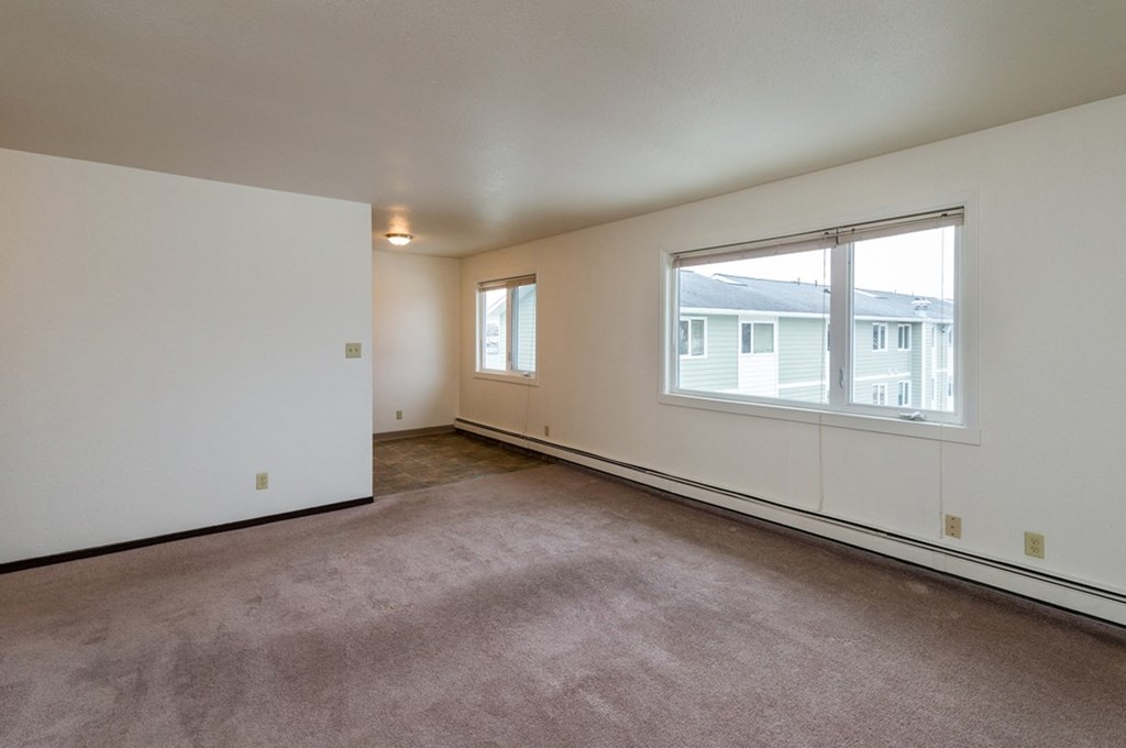 the living room of an apartment with a large window