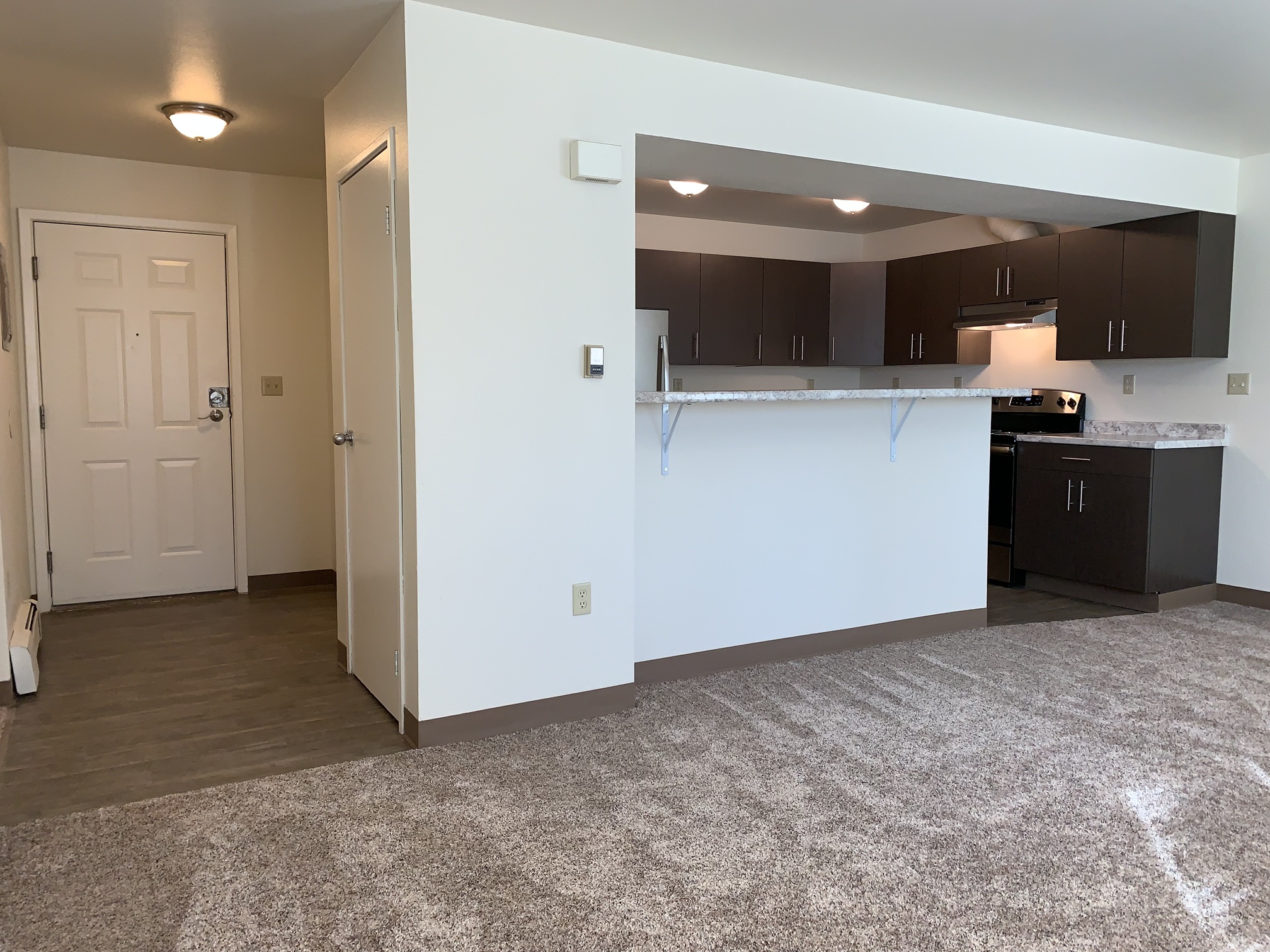 A kitchen area with a white wall and a countertop.