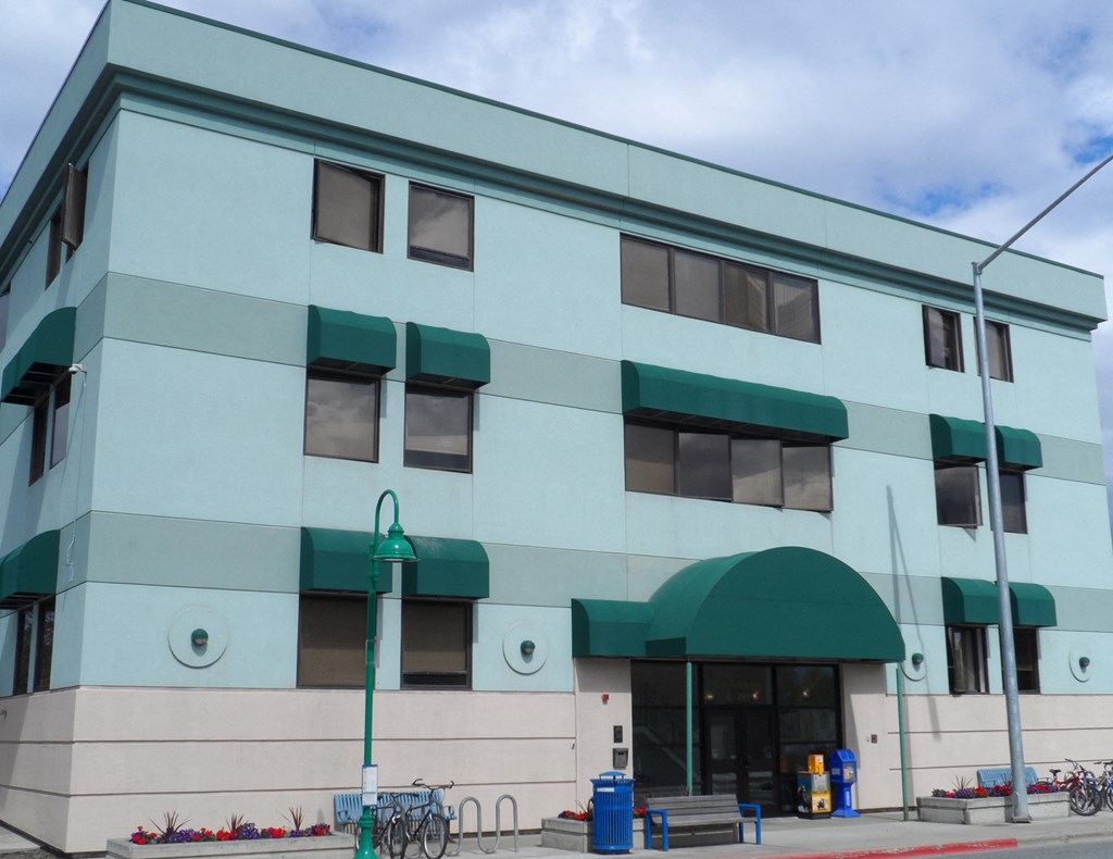 a large building with green awnings and a sidewalk