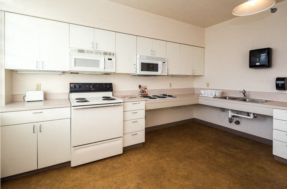 a white kitchen with white appliances and white cabinets