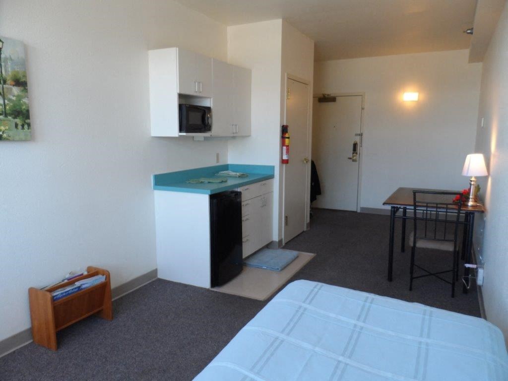 a hotel room with a kitchen and a bed