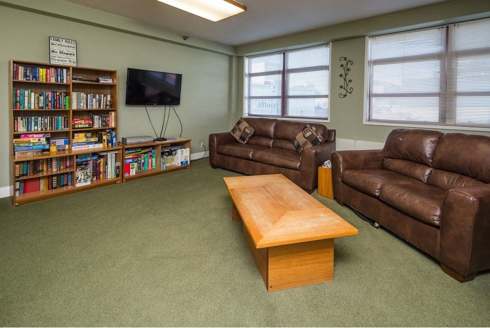 a living room with couches a coffee table and a television