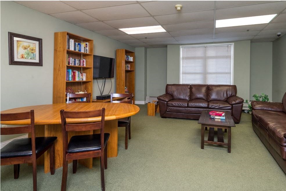 a living room with a table and leather furniture