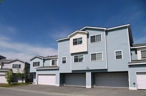 A large blue house with a garage door.