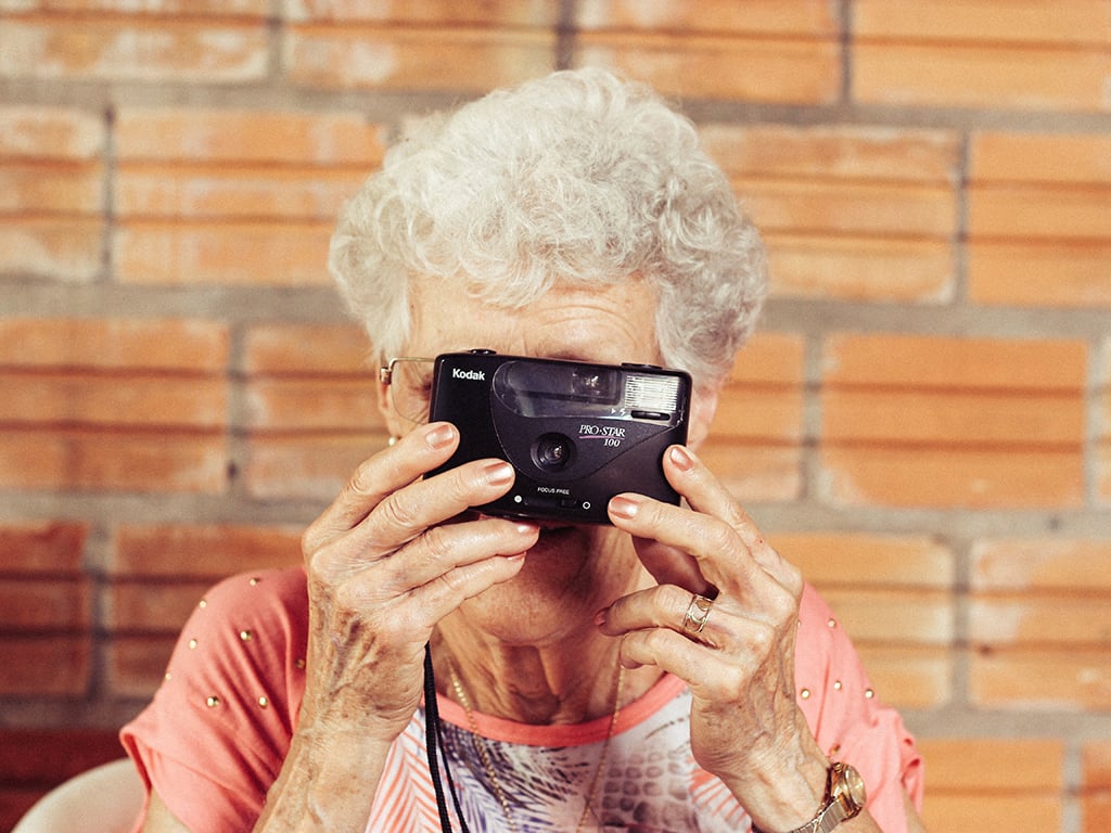 an older woman taking a picture with a camera