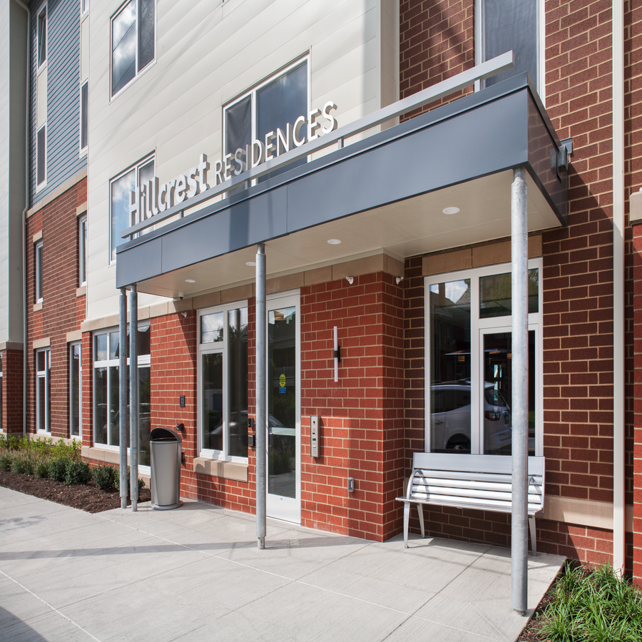 the front entrance of a building with a bench outside