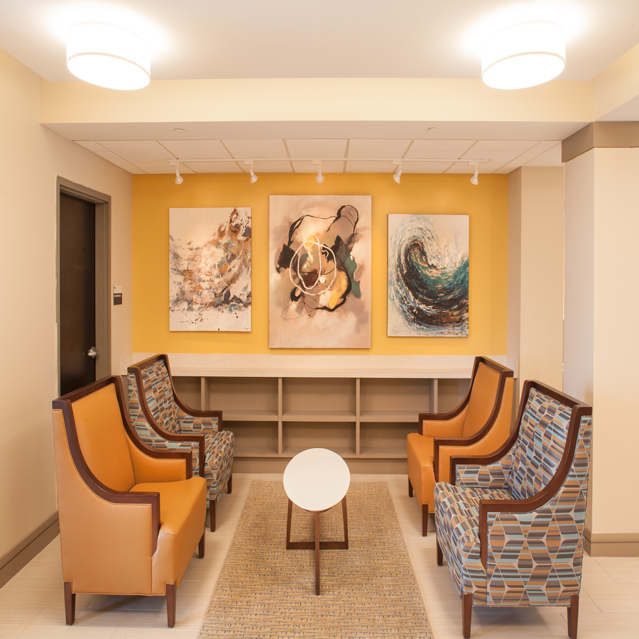 a waiting room with chairs and paintings on the wall