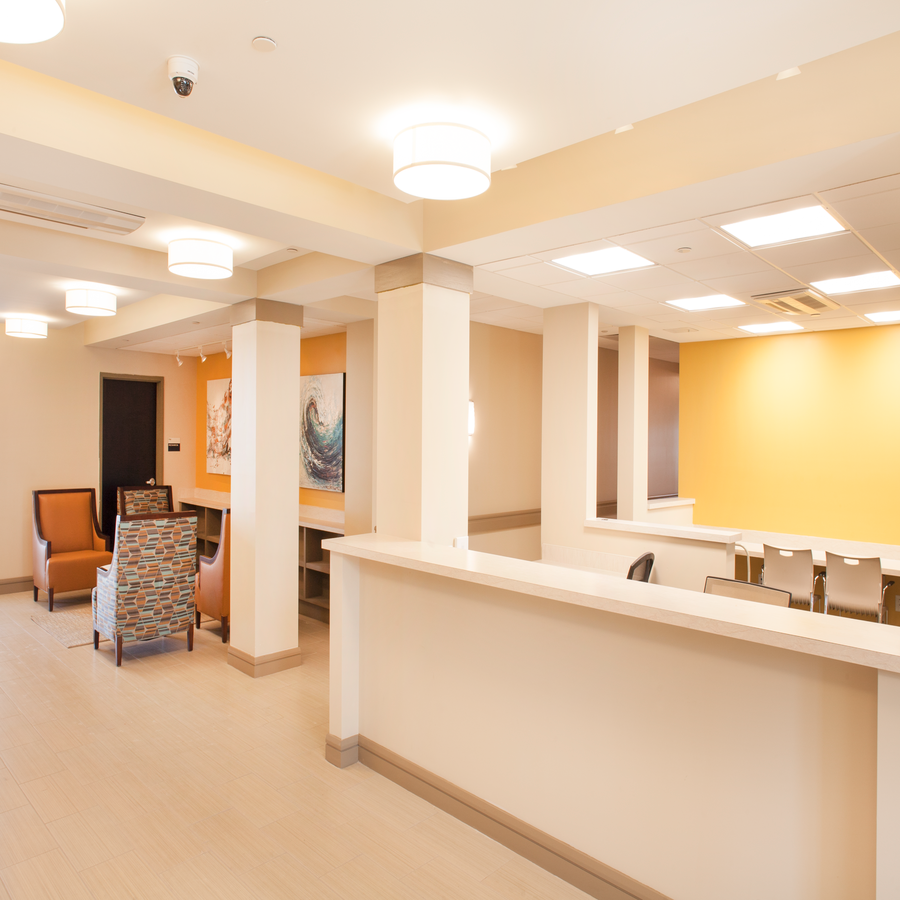 a large lobby with a reception desk and chairs