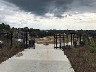 a walkway with a fence and a cloudy sky