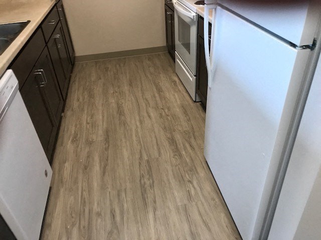 a kitchen with wood flooring and a refrigerator