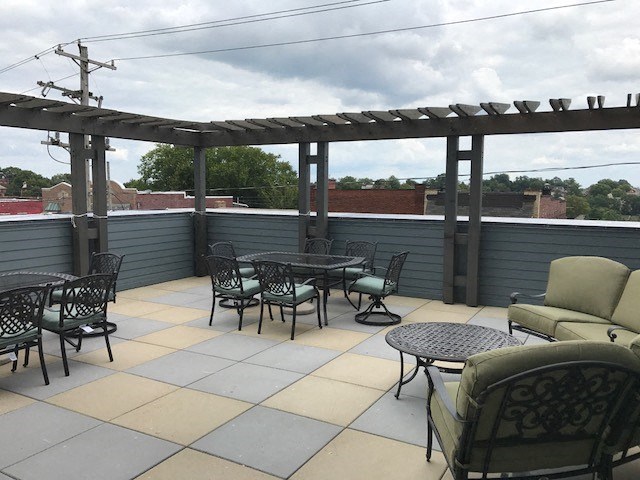 a patio with chairs and tables on a roof