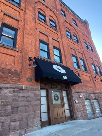 the front of a brick building with a black awning