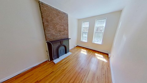 A room with a fireplace and wood flooring.