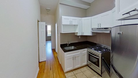 A kitchen with white cabinets and a stainless steel refrigerator.