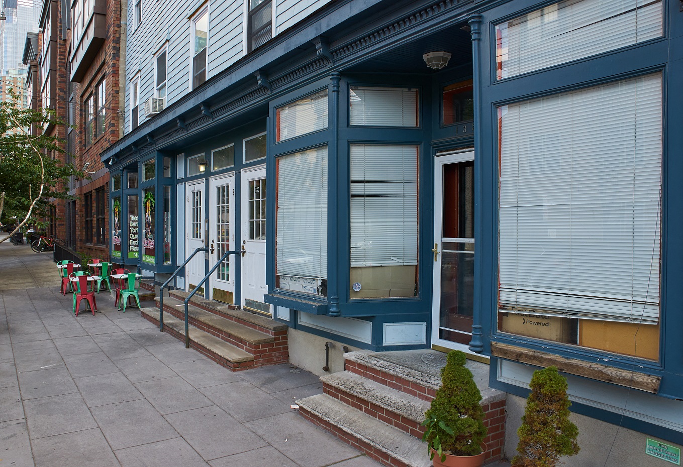 A blue building with a red door and steps leading up to it.