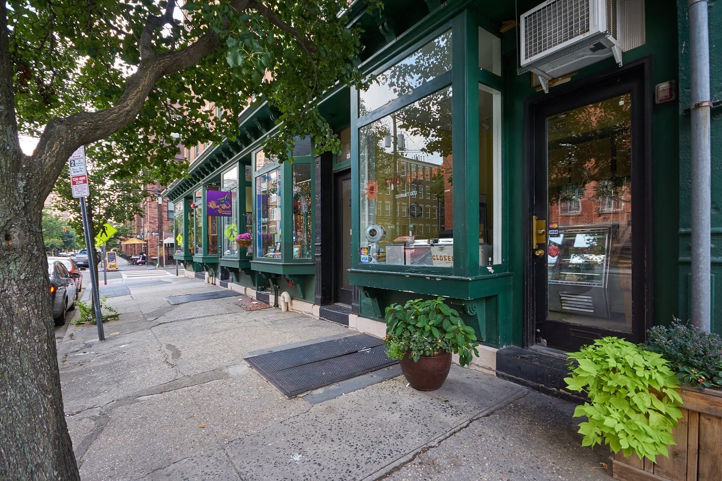 A green building with a tree in front of it.