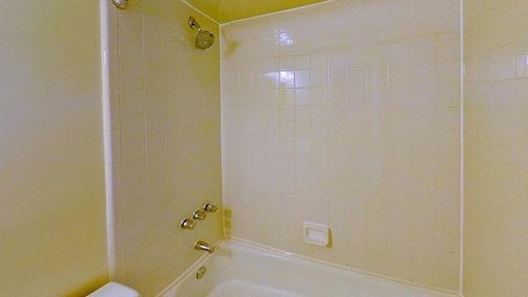 A white bathroom with a shower and a toilet.