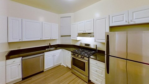A kitchen with white cabinets and a black stove top.
