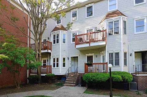 A white apartment building with a red brick building next to it.