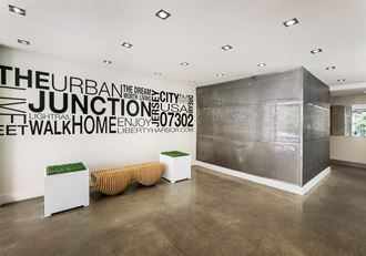a lobby with a bench and a wall with words on it