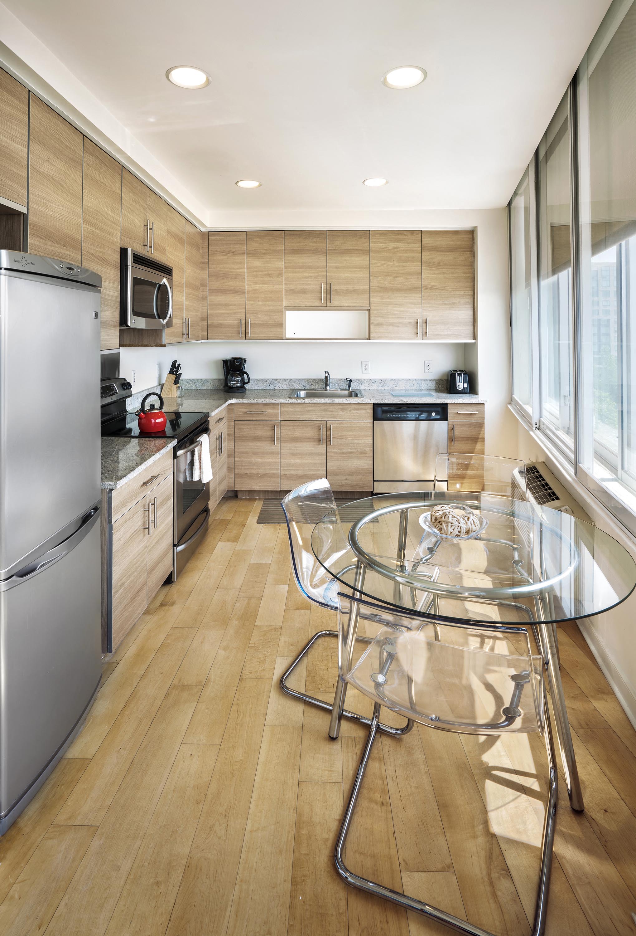 a large kitchen with a glass table in the center