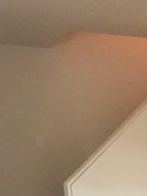 a living room featuring wall-to-wall carpeting, white walls, and a stairwell