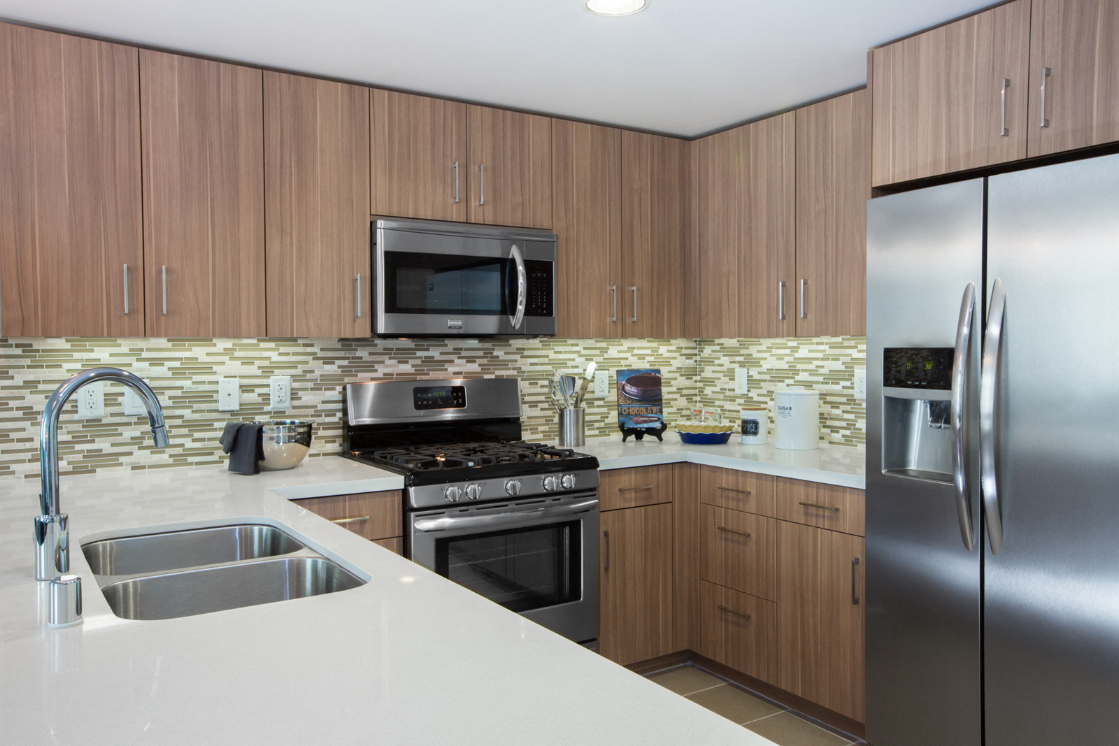 Cupertino, CA Apartments - Nineteen800 - Kitchen With Brown Cabinets, Stainless-Steel Appliances, And Quartz Countertops