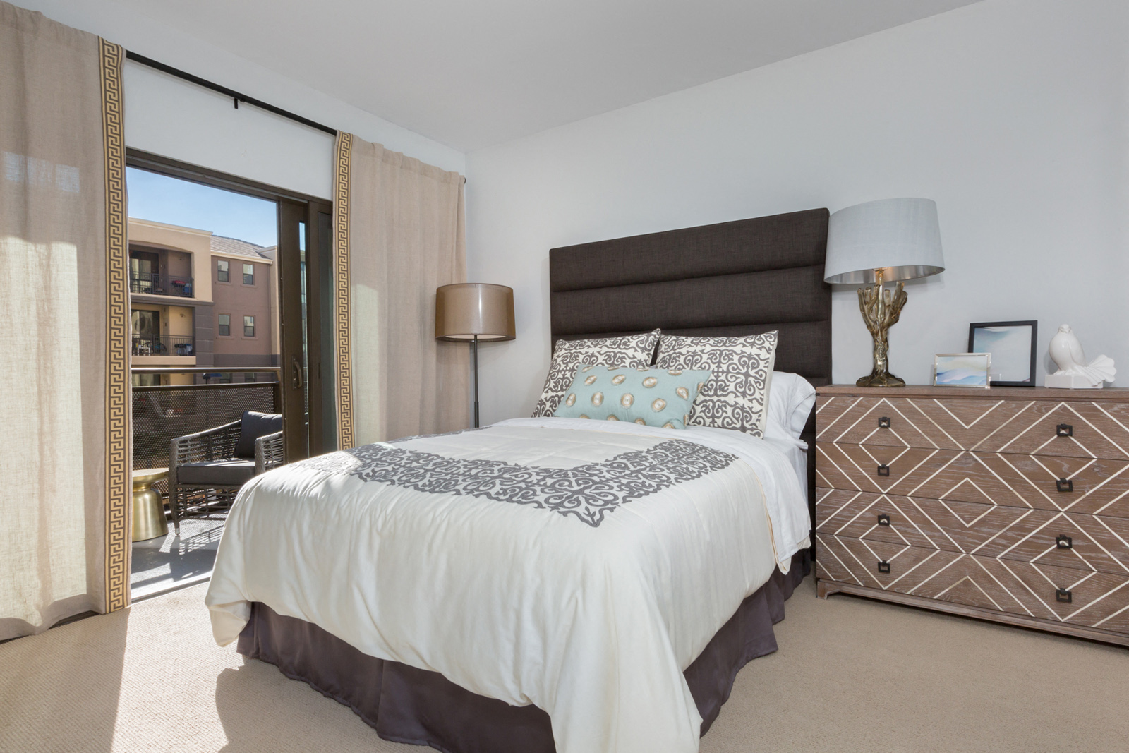 3 BR Apartments in Cupertino CA - Nineteen800 - Spacious Bedroom with Bed, Dresser, Lamps, Carpet, and Sliding Glass Door with Access to Private Balcony