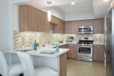 a kitchen with a white island and a stainless steel stove