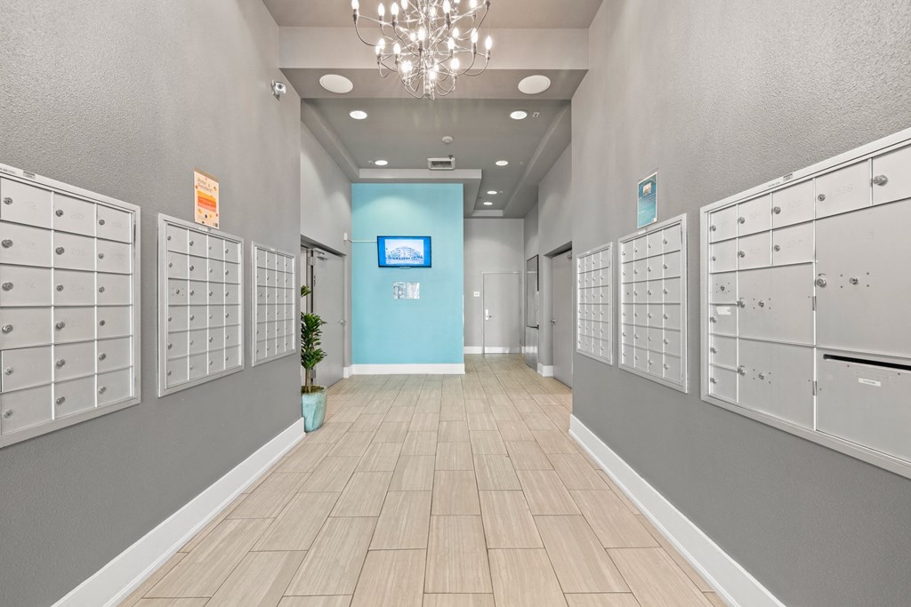 a long hallway with lockers and a chandelier