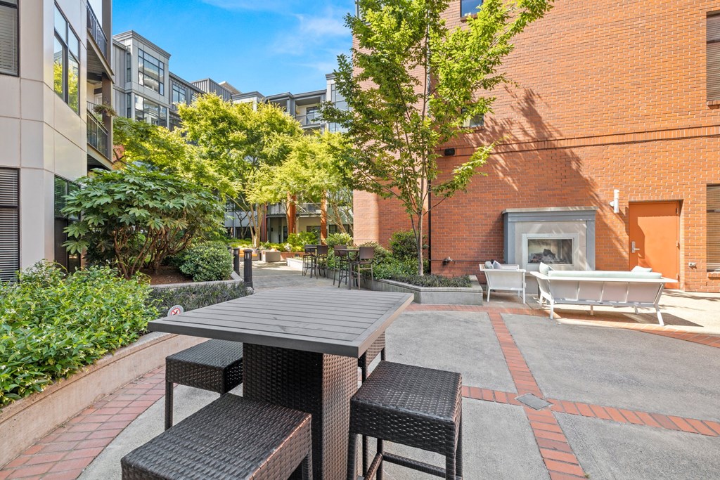 an outdoor patio with a table and chairs and a fireplace