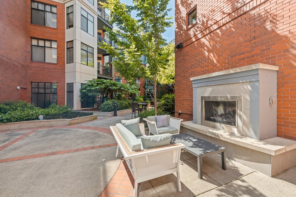 a patio with a fireplace and a table in front of a building