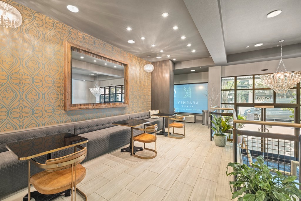 the lobby of a restaurant with tables and chairs and a large mirror