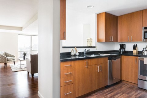 a kitchen with wooden cabinets and a sink in a living room