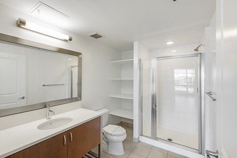 A white bathroom with a sink, toilet, and shower.