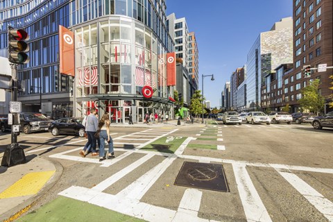 A crosswalk in a city with people walking across it.