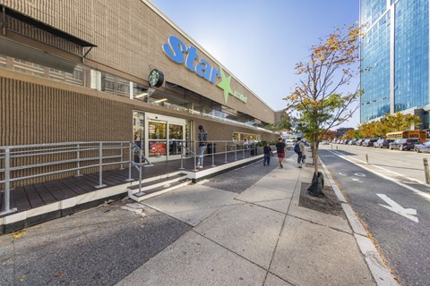 A Starbucks coffee shop is located on a sidewalk in front of a building.