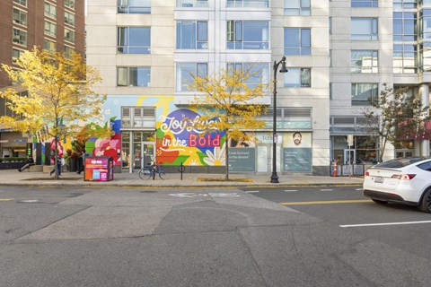 A mural on a building says "Toy Story" in the background.