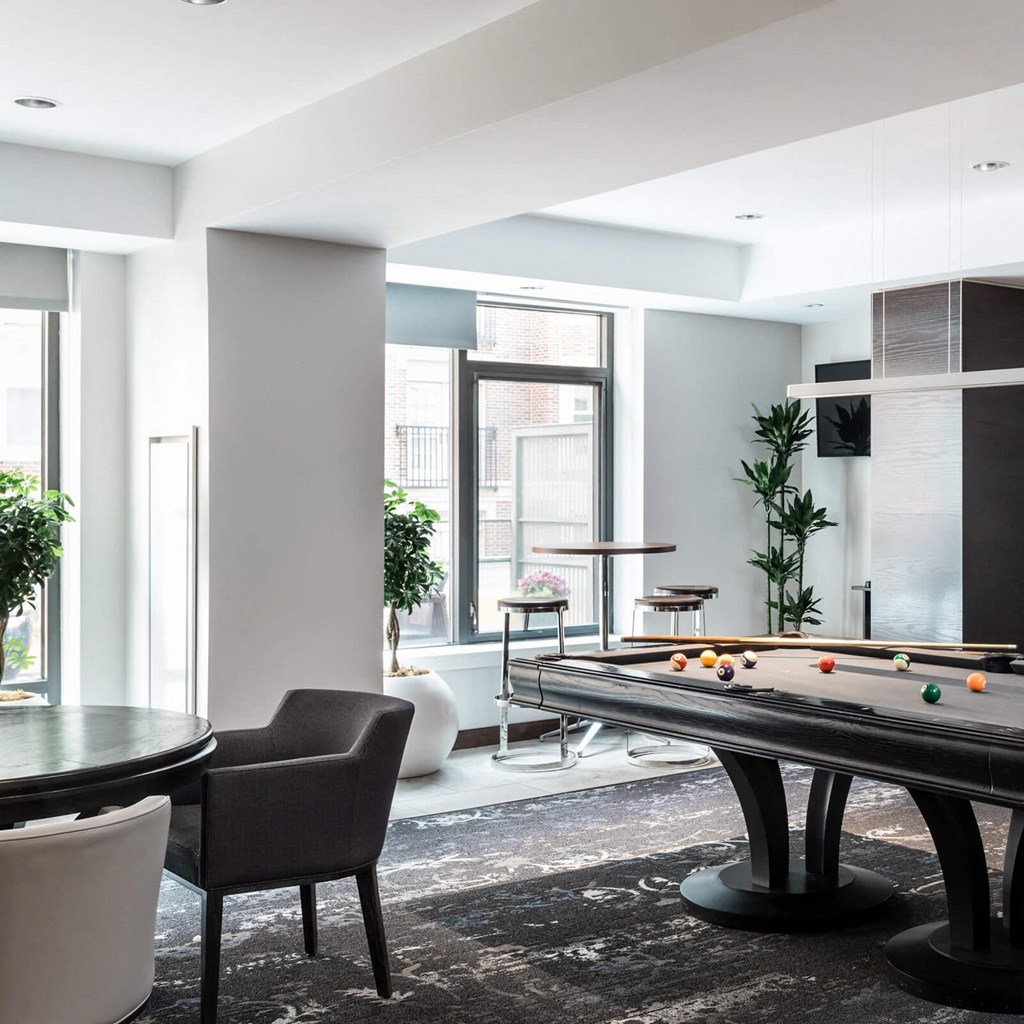 a living room with a pool table and a large window