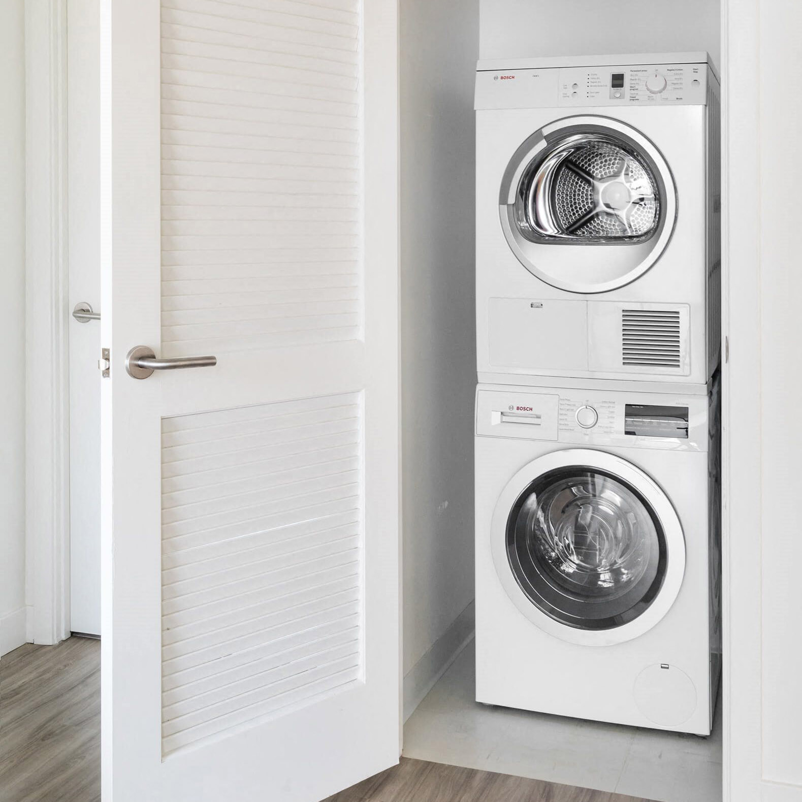 a white washer and dryer in a white closet
