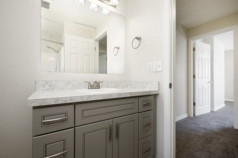View of Bathroom Vanity with Grey Cabinets, Mirror, and Lighting at Woodlake Townhomes, Edmonds, WA