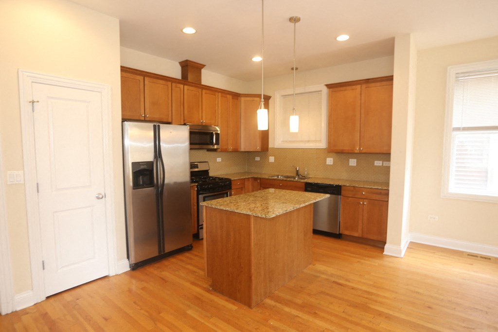 a kitchen with stainless steel appliances and wooden cabinets